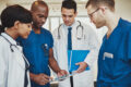 Team of multiracial doctors at hospital discussing a patient, Doctors using tablet